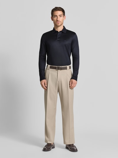 Männermodel trägt Slim Fit Poloshirt aus Lyocell-Mix von Emporio Armani in Dunkelblau, dezente Textur, Ganzkörperansicht von vorne.