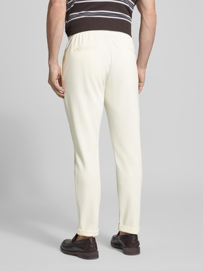 Męski model trägt Regular Fit Hose mit elastischem Bund von Antony Morato, mieszanka bawełny, krój regular fit, szerokość w rozmiarze M: 41 cm, długość wewnętrzna nogawki: 76 cm, jasny kolor, gładka faktura, widoczne pionowe szwy, widok całej sylwetki od tyłu.
