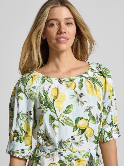 Frauenmodel trägt Minikleid mit Bindegürtel von Marc Cain aus reiner Baumwolle mit Zitronen-Allover, gerader Schnitt, Rundhalsausschnitt, Nahaufnahme Oberkörper.