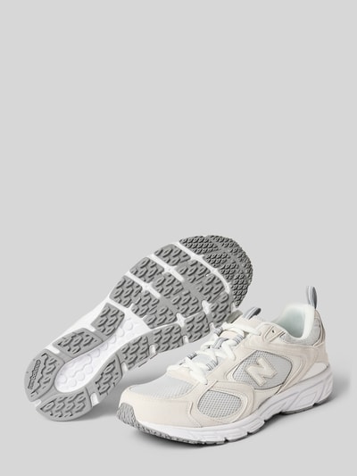 Produktfoto, Sneaker mit Schnürverschluss Modell '408' von New Balance in Weiß und Grau, abgerundete Form, strukturierte Sohle, Label-Detail