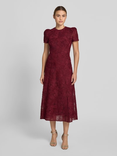 Frauenmodel trägt Maxikleid mit floralem Allover-Besatz von ROTATE aus Elastischer-Material-Mix, taillierte Passform, Rundhalsausschnitt, kurzärmelig, bordeauxrot, strukturierte Oberfläche, Gesamtlänge 133 cm, Brustweite 45 cm, Ärmellänge 22 cm, Ganzkörperansicht von vorne.