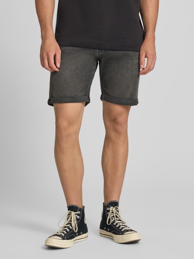 Männermodel trägt Regular Fit Jeansshorts mit Umschlag Modell 'RICK' von Jack & Jones aus Baumwoll-Elasthan-Mix, Eingrifftaschen, Ganzkörperansicht von vorne. Bundweite bei Größe M 42 cm, Innenbeinlänge 21 cm.