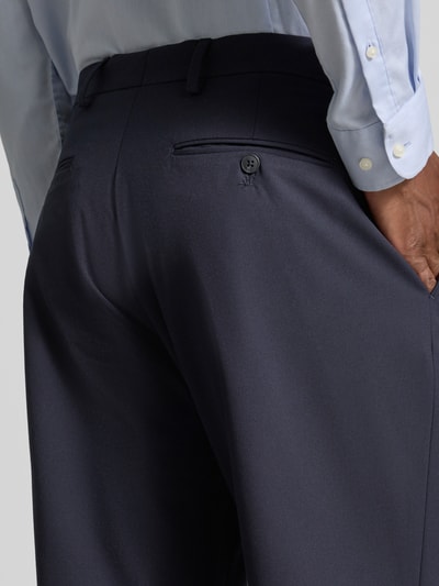 Männermodel trägt eine dunkelblaue Loose Fit Anzughose mit Gürtelschlaufen Modell 'LOOSE-LIAM' von Selected, feine Struktur, Nahaufnahme Rückansicht, Herren Anzughose von Selected.