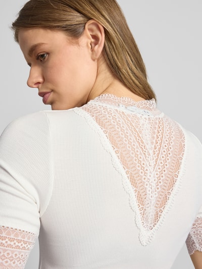 Frauenmodel trägt Slim Fit T-Shirt aus Viskose-Mix Modell 'Tilde' von Only in Optik: Unifarben mit Spitzenbesatz, Feinripp-Struktur, Nahaufnahme Rückansicht.