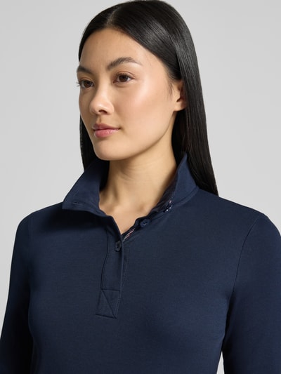 Kobiece modelka nosi Slim Fit Longsleeve aus Baumwoll-Mix von Marc Cain, mieszanka bawełny, krój slim fit, stójka, listwa guzikowa, długość tyłu w rozmiarze 36: 55 cm, kolor granatowy, gładka struktura, zbliżenie górnej części ciała z przodu.