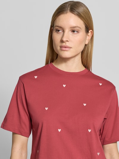 Modelka kobieca nosi T-Shirt mit 1/2-Arm od Jake*s Casual z bawełny, luźny krój, okrągły dekolt, kolor ciemnoczerwony z białymi sercami, półrękaw, długość tyłu w rozmiarze S: 55 cm, zbliżenie na górną część ciała