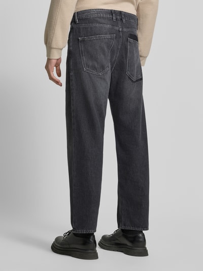 Männermodel trägt Baggy Fit Jeans aus reiner Baumwolle von DRYKORN, dunkelgrauer Denim, 5-Pocket-Design, Ganzkörperansicht Rückansicht.