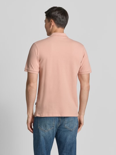 Männermodel trägt Slim Fit Poloshirt mit Stitching von Jack & Jones Premium in Rosa mit kurzer Knopfleiste, Ganzkörperansicht Rückansicht.