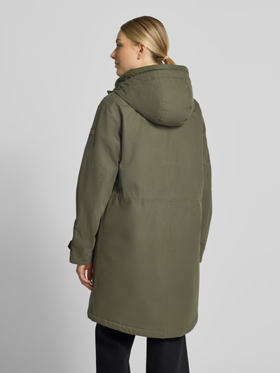 Frauenmodel trägt Parka mit Kapuze und Pattentaschen von camel active in Olivgrün, Baumwoll-Mix, Ganzkörperansicht Rückansicht. Rückenlänge 94 cm, Schulterbreite 42 cm, Brustweite 56 cm, Ärmellänge 64 cm, Relaxed Fit, verdeckter Reißverschluss, Ärmelriegel.
