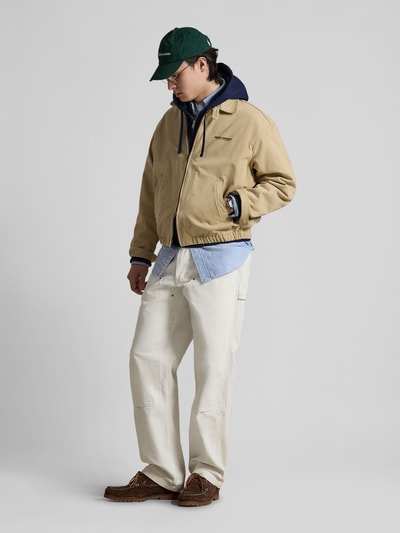 Männermodel trägt Regular Fit Blouson aus reiner Baumwolle von Polo Ralph Lauren in Beige, unifarben, Twilltextur, Ganzkörperansicht von vorne.