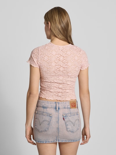 Frauenmodel trägt Slim Fit T-Shirt aus Spitze Modell 'FAITH' von Only in Rosa, Spitzenmuster, Frill-Abschlüsse, Ganzkörperansicht Rückansicht.