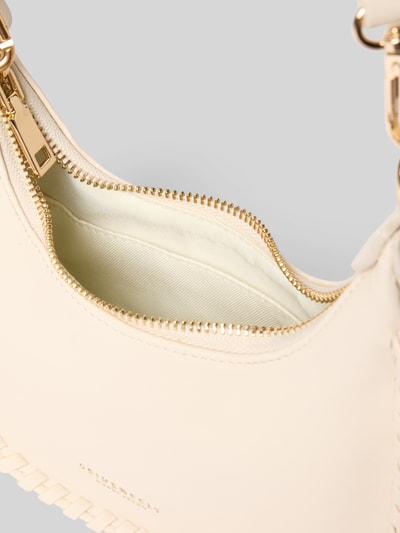 Produktfoto, cremefarbene Half Moon Bag mit Label-Detail Modell 'LILJENDAL' von Seidenfelt, Reißverschluss, Hauptfach, weiche Struktur, goldfarbene Details, verstellbarer Schultergurt, Breite 18 cm, Länge 18 cm, Tiefe 8 cm, Länge Schulterriemen 118 cm.