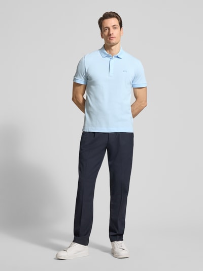 Męski model nosi Regular Fit Poloshirt aus Baumwoll-Mix von Lacoste, efekt: jednolity kolor, wyhaftowane logo, krótki rękaw, pika, mieszanka bawełny, całkowity widok z przodu.