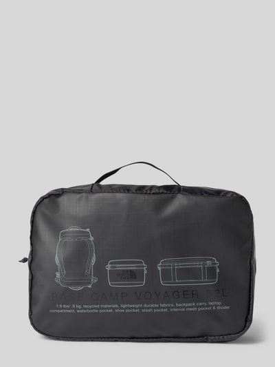 Produktfoto, Duffel Bag mit Logo-Print Modell 'Voyager' von The North Face, schwarze Oberfläche mit Konturlinien und Logo, rechteckige Form, sichtbare Textur glatten Stoffs, Innenfächer und Reißverschluss erkennbar, Kontext: Hauptfach mit Reißverschluss, verstellbare Schulterriemen, Innenfächer mit Reißverschluss, Maße 30x20x9 cm, Schulterriemenlänge 13 cm, minimalistisches Design
