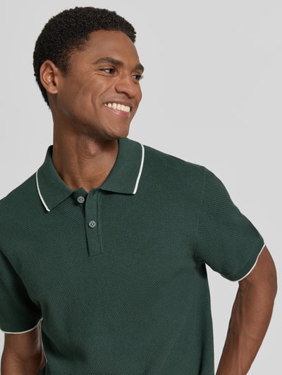 Männermodel trägt Regular Fit Poloshirt mit Kontrastkante von Christian Berg Men, Reine Baumwolle, Strukturmuster, Nahaufnahme Oberkörper.