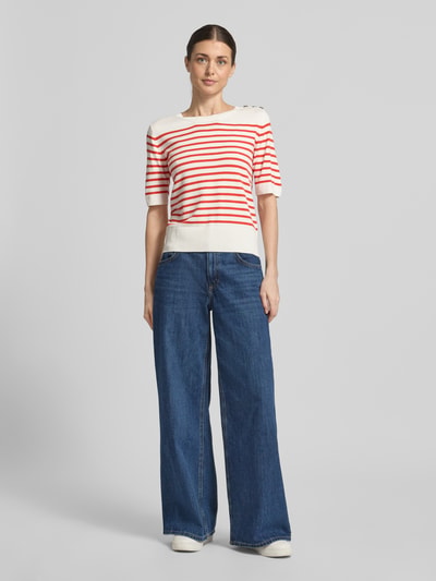 Frauenmodel trägt Strickshirt aus Viskose-Elasthan-Mix mit Knopfleiste von Milano Italy in Weiß mit roten Streifen, Regular Fit, Rundhalsausschnitt, dazu weite Jeans, Ganzkörperansicht von vorne.