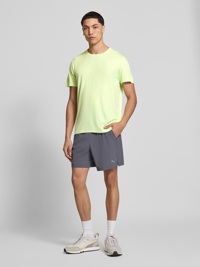 Männermodel trägt TRAINING T-Shirt mit Label-Detail Modell von PUMA PERFORMANCE, Herren T-Shirt, Gerader-Schnitt, Rundhalsausschnitt, Kurzärmelig, Rückenlänge bei Größe M: 73 cm, Ganzkörperansicht von vorne.