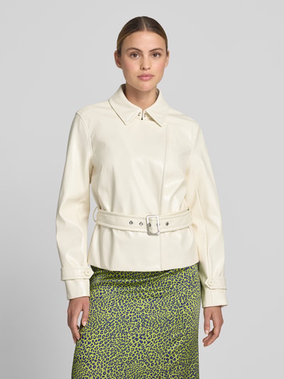 Frauenmodel trägt Jacke mit Gürtel und Ärmelriegeln von Marc Cain in Creme, Regular-Fit, Hakenverschluss, glatte Textur, Nahaufnahme Oberkörper, Rückenlänge bei Größe 36: 58 cm, Schulterbreite 40 cm, Brustweite 48 cm, Ärmellänge 61 cm.
