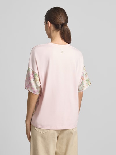 Kobiece model prezentuje T-shirt aus Viskose-Elasthan-Mix Modell 'Tracy' von JOOP!, wzór na całej powierzchni, krój regular fit, okrągły dekolt, długość tyłu w rozmiarze 36: 61 cm, widok całej sylwetki z tyłu.