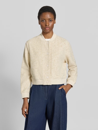Frauenmodel trägt Regular Fit Sweatjacke mit Baseball-Kragen Modell 'BERNICE L' von Brax in Creme, strukturierte Oberfläche, dunkelblaue Hose, Nahaufnahme Oberkörper, Damen Sweatjacke von Brax.