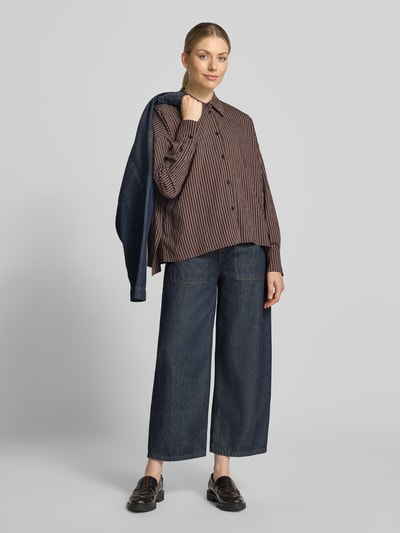 Vrouwenmodel draagt Relaxed Fit blouse met overhemdkraag, knoopsluiting, all-over look van Viscosemix, Model 'CLOELIA' van DRYKORN, voorkant geheel in beeld. Ruglengte maat 36: 74 cm, mouwlengte: 51 cm.