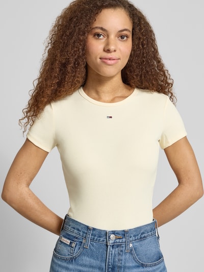 Frauenmodel trägt Slim Fit T-Shirt aus Baumwoll-Mix von Tommy Jeans, Optik: Unifarben, Applikation: Logo-Stitching, Ripp, Ganzkörperansicht von vorne.