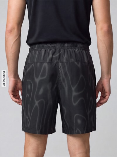 Männermodel trägt schwarze Regular Fit Sportshorts mit Dri-FIT-Technologie von Nike, wellige Muster, Herren Sportshorts, Ganzkörperansicht Rückansicht, KI-modifiziertes Bild.