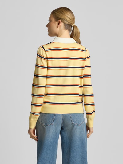 Frauenmodel trägt Regular Fit Poloshirt mit Knopfleiste Modell 'PREGO' von SUNCOO PARIS, gestreifter Material-Mix mit Lanawoll-Anteil in Gelb, Rückenlänge bei Größe S 56 cm, Ärmellänge 64 cm, Ganzkörperansicht Rückansicht.