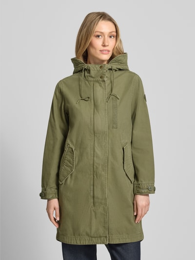 Kobiece modelka nosi parka z bawełny, krój relaxed fit, kaptur z tunel, kieszenie z patką, Parka mit Kapuze und Pattentaschen Modell 'FREYA' od khujo, długość tyłu w rozmiarze S: 94 cm, szerokość ramion w rozmiarze S: 41 cm, szerokość w rozmiarze S: 53 cm, długość rękawów w rozmiarze S: 58 cm, kolor khaki, tekstura gładka; widok całej sylwetki z przodu.