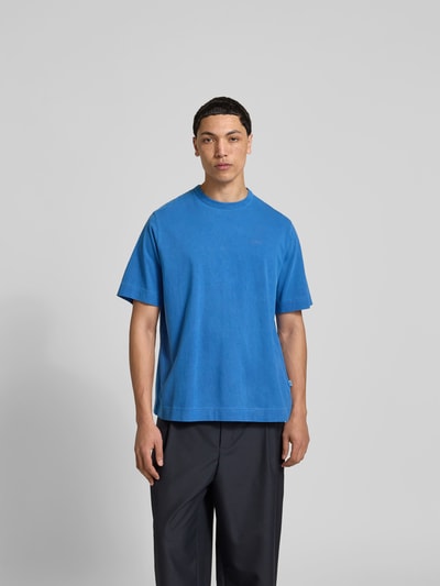Männermodel trägt Relaxed Fit T-Shirt mit Logo-Stitching von Forét in Blau, Reine Baumwolle, Rundhalsausschnitt, Kurzärmelig, Herren T-Shirt, Rückenlänge 70 cm, Ganzkörperansicht von vorne