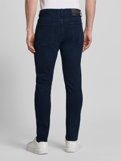 Männermodel trägt Slim Fit Jeans aus Baumwoll-Mix von Tommy Hilfiger in Melange-Optik mit Label-Patch, 5-Pocket-Design, Ganzkörperansicht Rückansicht.