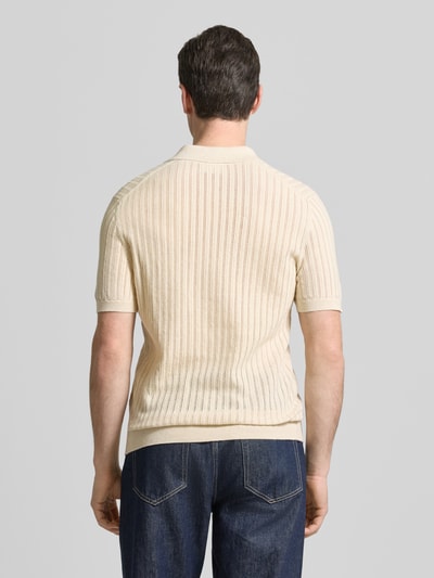 Mężczyzna nosi Slim Fit Poloshirt mit V-Ausschnitt von Profuomo z mieszanki bawełny i lnu, kolor beżowy, krój slim fit, kołnierzyk polo, dekolt w serek, długość tyłu w rozmiarze M: 67 cm, tekstura prążkowana, całkowity widok z tyłu.
