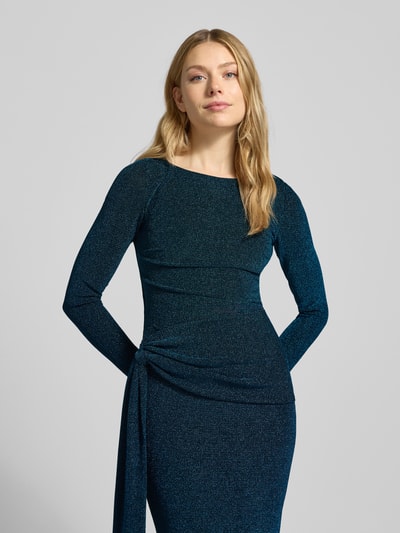 Kobiecy model nosi szmaragdowe, połyskujące maxi wieczorową suknię Schimmerndes Abendkleid mit Knotendetail Modell 'Eden' od Forever New, okrągły dekolt, dopasowany krój, długi rękaw, tekstura z połyskiem, detal węzła w talii, mieszanka materiałów z dodatkiem stretchu, widok z przodu, zbliżenie na górę.