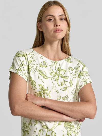 Frauenmodel trägt Relaxed Fit T-Shirt aus weichem Viskose-Mix von s.Oliver RED LABEL mit grünem floralem Allover-Muster, Nahaufnahme Oberkörper.