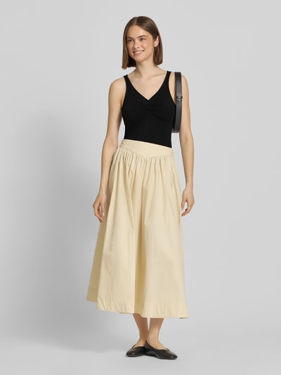 Frauenmodel trägt Slim Fit Top aus Viskose-Mix Modell 'MALIVA' von Pieces, unifarben schwarz, ohne Ärmel, V-Ausschnitt, Ganzkörperansicht von vorne.