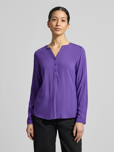 Vrouwenmodel draagt Regular Fit Blouse uit zuivere viscose met tuniekhals van Christian Berg Woman, knoopsluiting, lang, paarse effen kleur, vooraanzicht van het bovenlichaam. Context: dames blouse, zuivere viscose, regular fit, tuniekhals, knoopsluiting, met lange mouwen, ruglengte maat 36: 64 cm, mouwlengte maat 36: 60 cm.