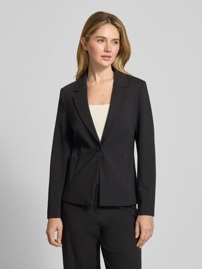 Frauenmodel trägt Blazer mit Reverskragen von Comma aus schwarzem Viskose-Mix mit Stretch-Anteil, Slim Fit, Knopfverschluss, Nahtreißverschlusstaschen, Rückenlänge 60 cm, Brustweite 43 cm, Ärmellänge 61 cm, Ganzkörperansicht von vorne.