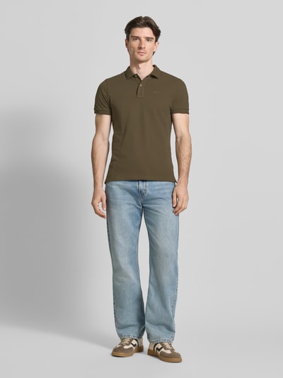 Männermodel trägt Slim Fit Poloshirt mit Logo-Stitching von Geox aus Reine Baumwolle mit Strukturmuster, Polokragen, Kurzärmelig, Ganzkörperansicht von vorne.