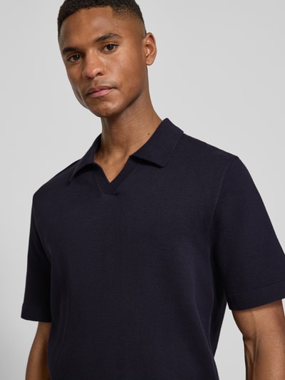 Männermodel trägt Strickshirt mit V-Ausschnitt Modell 'MILANO' von Jack & Jones Premium, dunkelblauer Baumwoll-Mix, Nahaufnahme Oberkörper.