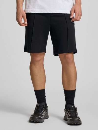 Mannelijk model draagt zwarte Sweatshorts met logo model 'KANE' van Jack & Jones, relaxed fit, elastische tailleband, katoenmix, vooraanzicht lichaam