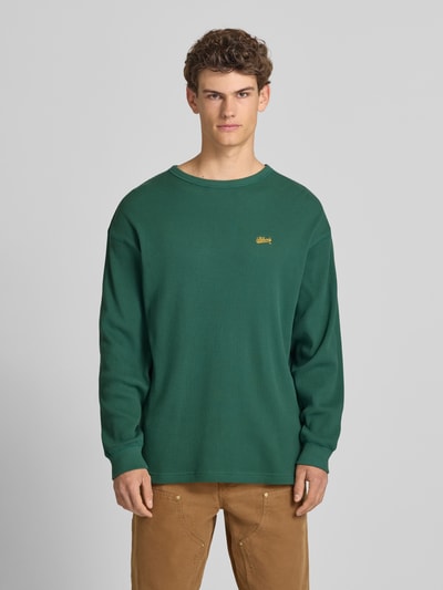 Mannelijk model draagt BLKVIS Longsleeve met Logo-Stitching van puur katoen, loose fit, structuurpatroon, ronde hals, ruglengte maat S 75 cm, groen, Ganzkörperansicht von vorne.
