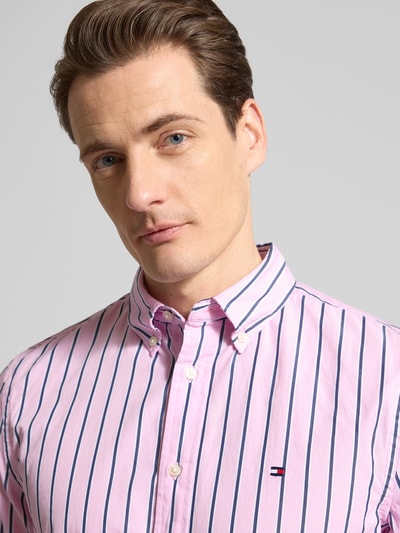 Mężczyzna nosi Regular Fit Freizeithemd aus reiner Baumwolle od Tommy Hilfiger, różowe w niebieskie paski, logo, popelina, zbliżenie na górę ciała.