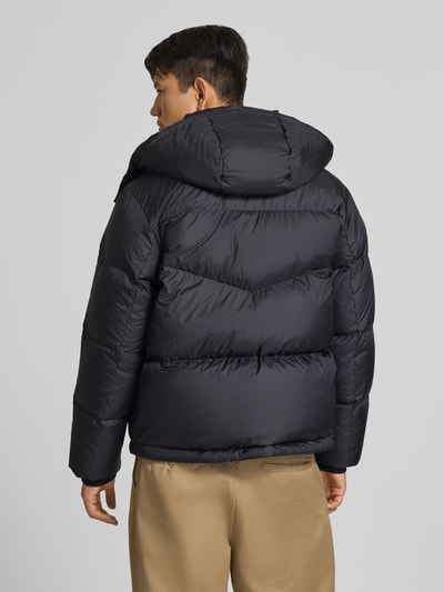 Männermodel trägt Regular Fit Daunenjacke mit Kapuzenkragen von Marc O'Polo in Dunkelblau, glatt gesteppt, Ganzkörperansicht Rückansicht. Herren Steppjacke von Marc O'Polo DENIM.