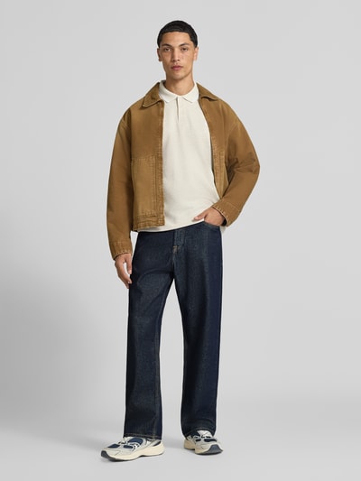 Männermodel trägt Wide Fit Jeans aus reiner Baumwolle Modell 'Alex' von JACK & JONES in Dunkelblau, 5-Pocket-Design, Ganzkörperansicht von vorne.