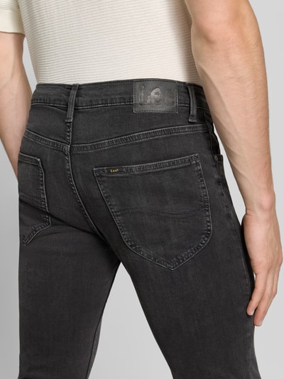 Männermodel trägt Slim Fit Jeans aus Baumwoll-Mix Modell 'Luke' von Lee in dunklem Grau, Herren Slim Fit Jeans von Lee, Ganzkörperansicht Rückansicht.