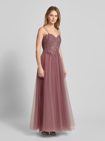 Modelka nosi Sukienka wieczorowa 'Abendkleid mit floralem Spitzenbesatz' od Mascara z tiulu, krój taliowany, góra z obszyciem koronką i ozdobnymi kamieniami, cienkie ramiączka, halka pod spódnicę, wszyty zamek błyskawiczny, spódnica rozkloszowana, długość tyłu w rozmiarze 36: 17 cm, szerokość w rozmiarze 36: 37 cm; ujęcie całej sylwetki z przodu.