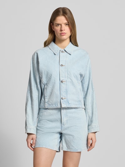 Frauenmodel trägt Jeansjacke mit Eingrifftaschen Modell 'DOLEMAN TRUCKER' von Calvin Klein Jeans in Hellblau, Reine Baumwolle, Gerader-Schnitt, Kentkragen, Knopfleiste, Ganzkörperansicht von vorne.