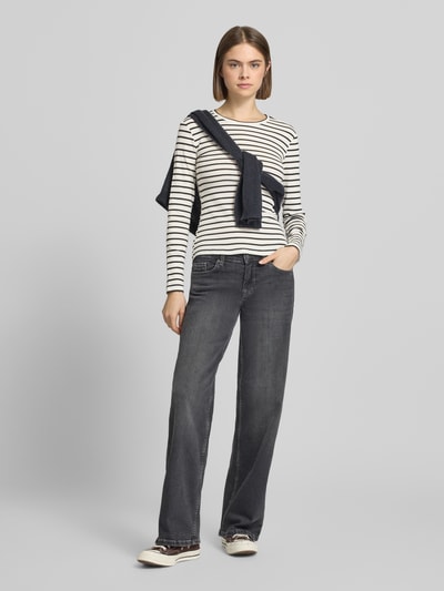 Modelka kobieca nosi Slim Fit Langarmshirt aus Baumwoll-Mix od Pieces, krój slim fit, wzór w paski, dwukolorowy rippstrick, okrągły dekolt, długi rękaw, kolor biało-granatowy, jednolita optyka, widok całej sylwetki z przodu.