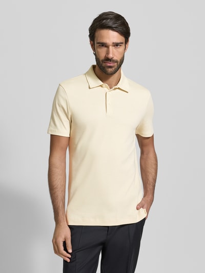 Männermodel trägt Regular Fit Poloshirt aus reiner Baumwolle Modell 'PALOSH' von BOSS, Optik: Unifarben, Label-Print, Polokragen, Kurzarm, mit Seitenschlitzen, Ganzkörperansicht von vorne.