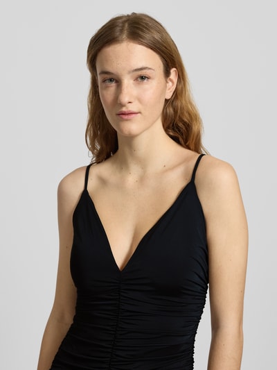 Frauenmodel trägt Slim Fit Abendkleid mit Raffungen Modell 'Lavanda' von Bardot in Schwarz mit Spaghettiträgern und V-Ausschnitt, elastischer Material-Mix, Nahaufnahme Oberkörper.